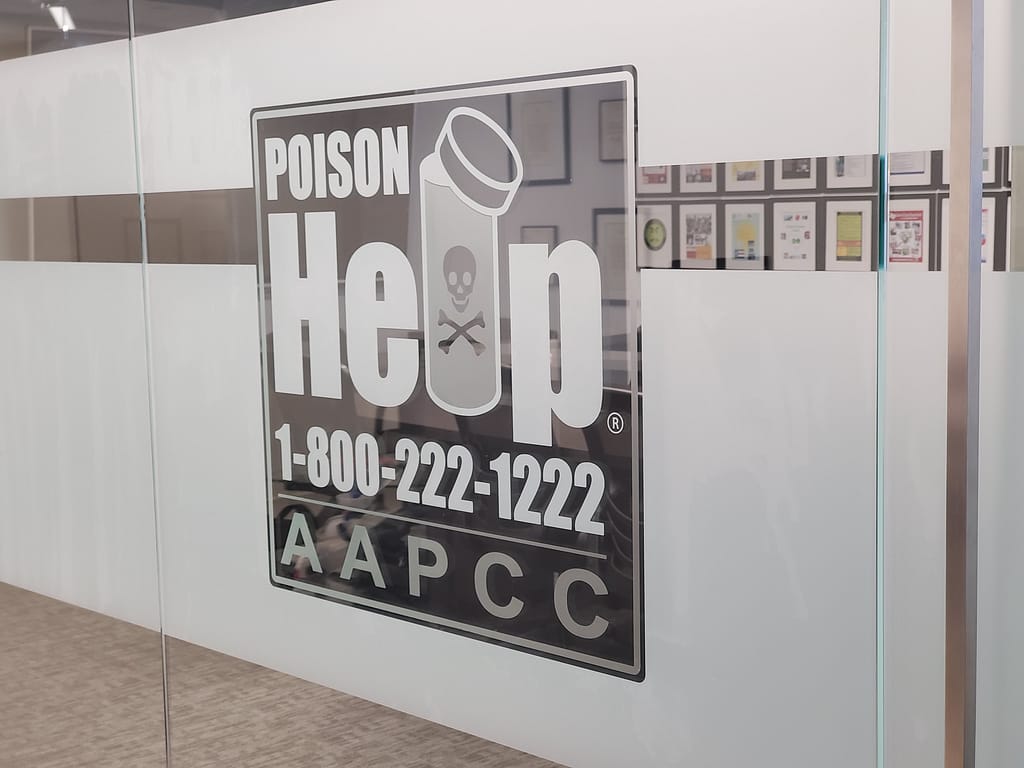 Logo applied to conference room glass created out of multiple frosted or etched window film. The logo says "Poison Help" a phone number and below it "AAPCC"