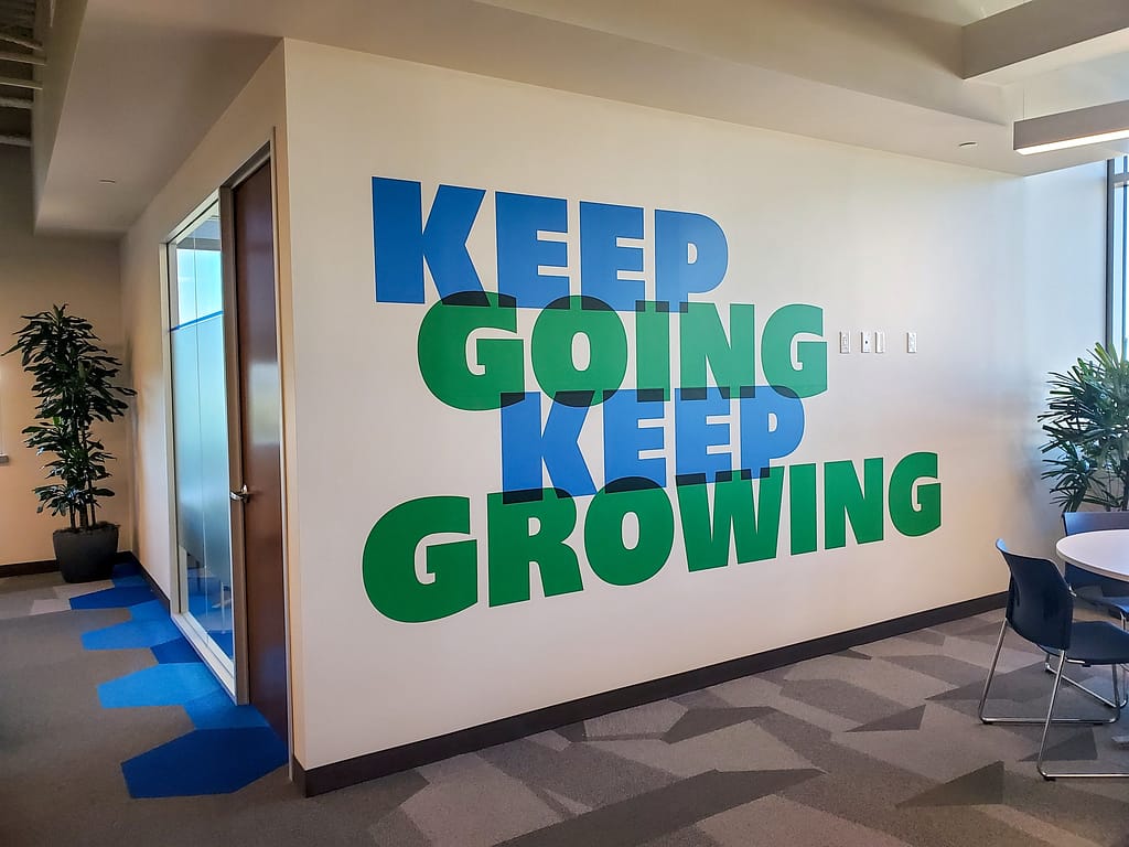 Large contour cut wall vinyl graphic with the words "Keep Going Keep Growing.