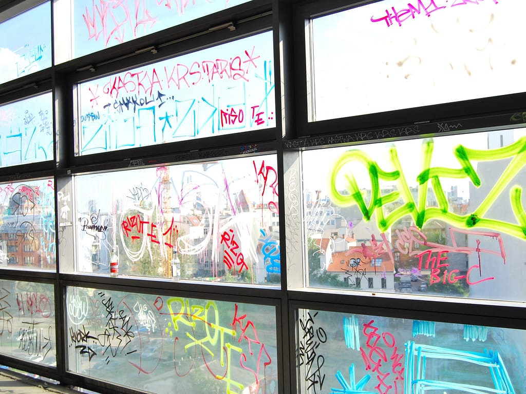 Graffiti on glass with anti-graffiti film applied to it.