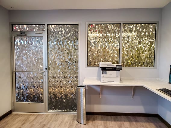 Textured window film applied to a glass door and a 4 other pieces of glass giving privacy in the room.