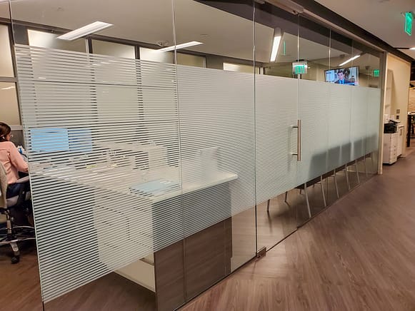 Glass wall in dentist office with a 48" band of striped patterned window film applied to the hallway side of the glass, obscuring reception and waiting room.